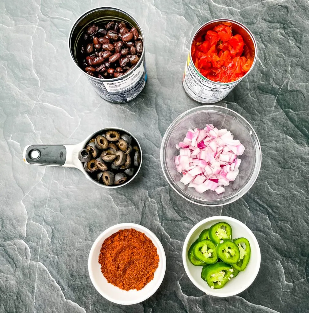 black beans, Rotel, olives, onions, jalapenos, and taco seasoning in separate bowls