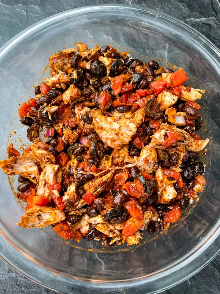 turkey, black beans, onions, Rotel, black olives, and taco seasoning in a glass bowl