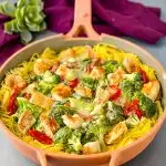 Spaghetti squash chicken alfredo in a pan with broccoli, spinach, and sundried tomatoes