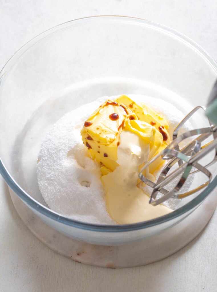 butter and sweetener in a glass bowl with a mixer