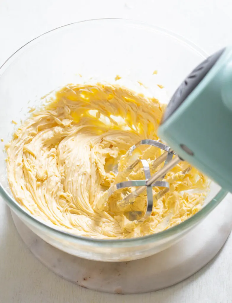 sugar free buttercream frosting in a glass bowl with a mixer