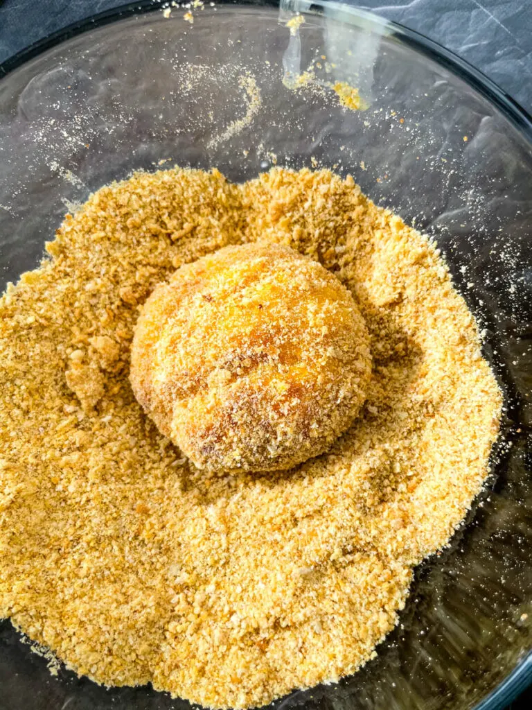 a hushpuppy dredged in breadcrumbs in a glass bowl