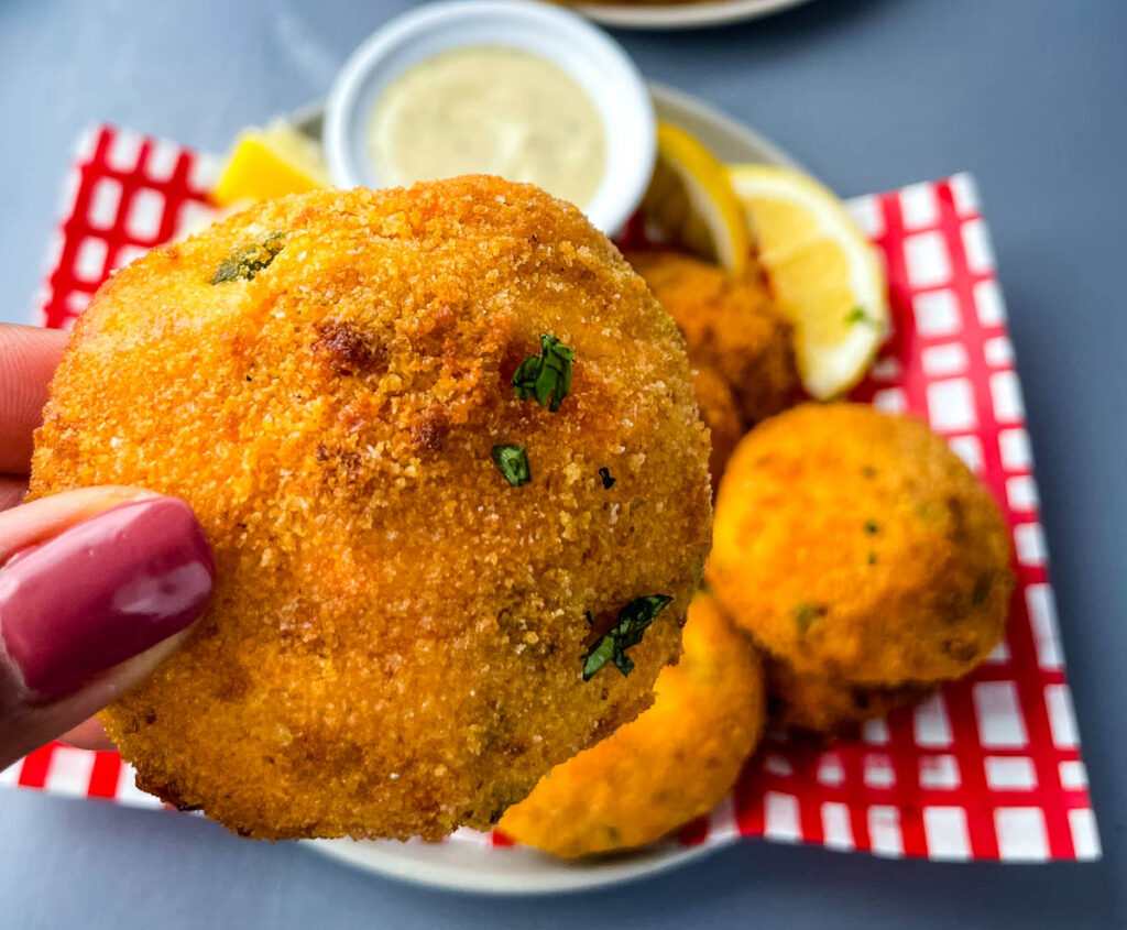 person holding an air fryer hush puppy