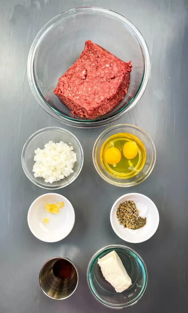 ground beef, chopped onions, raw eggs, cream cheese, garlic, and seasonings in separate glass bowls