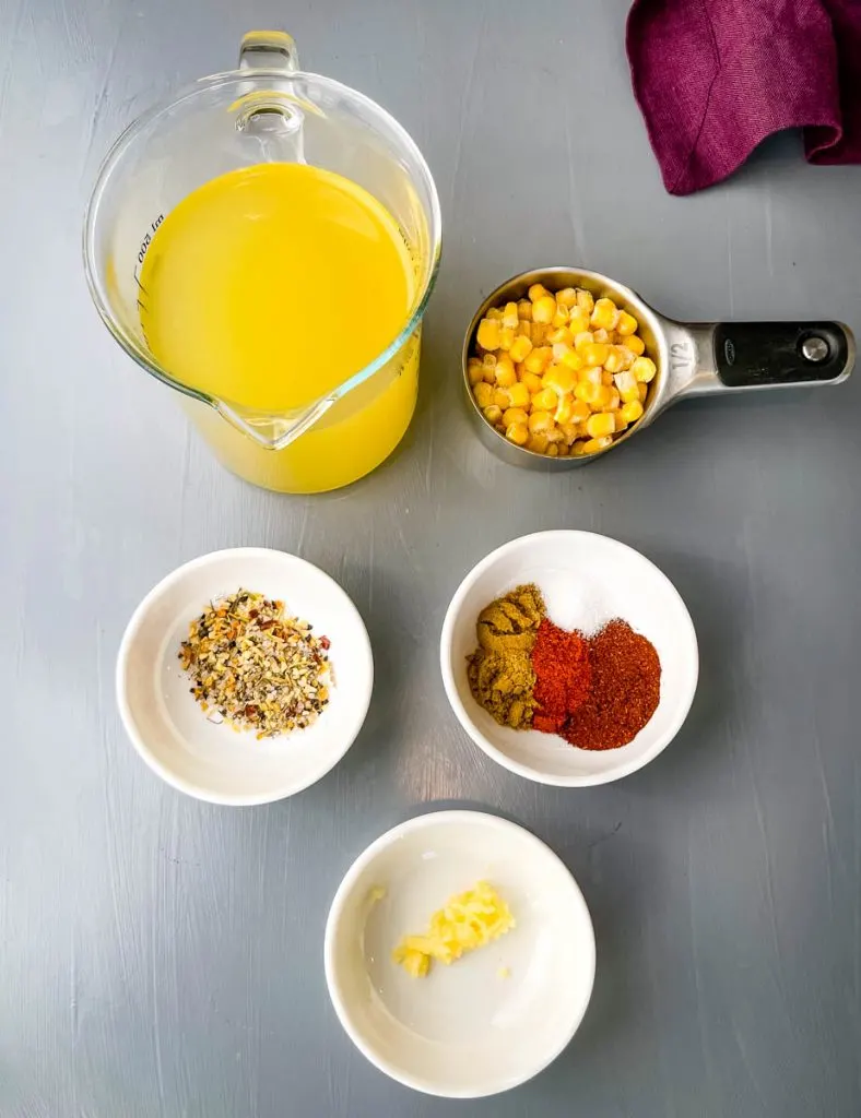 chicken broth, frozen corn, chili spices, and garlic in separate bowls