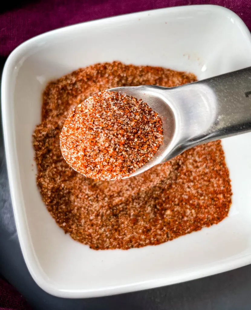 homemade bbq seasoning in a white bowl with a spoon