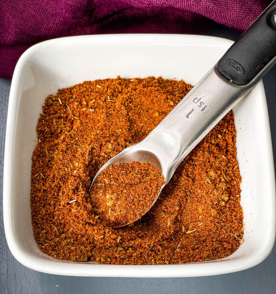 homemade chili seasoning in a white bowl with a spoon