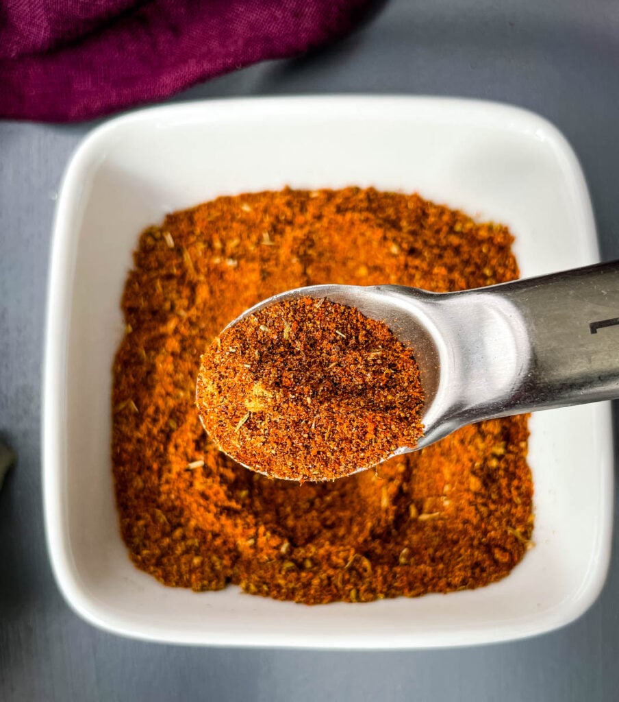 homemade chili seasoning in a white bowl with a spoon