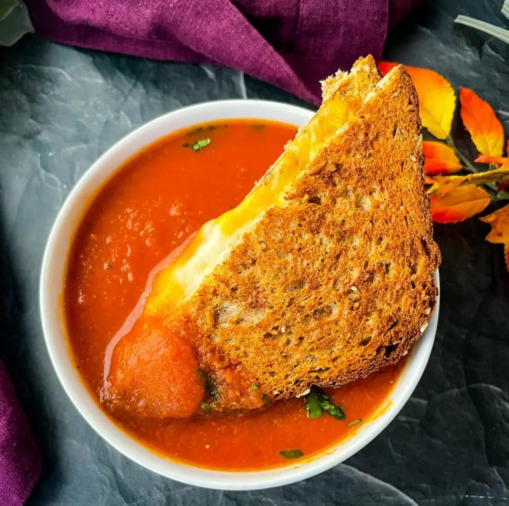 grilled cheese sandwich in a bowl of tomato soup