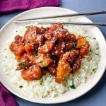 keto low carb orange chicken on a white plate with sesame seeds