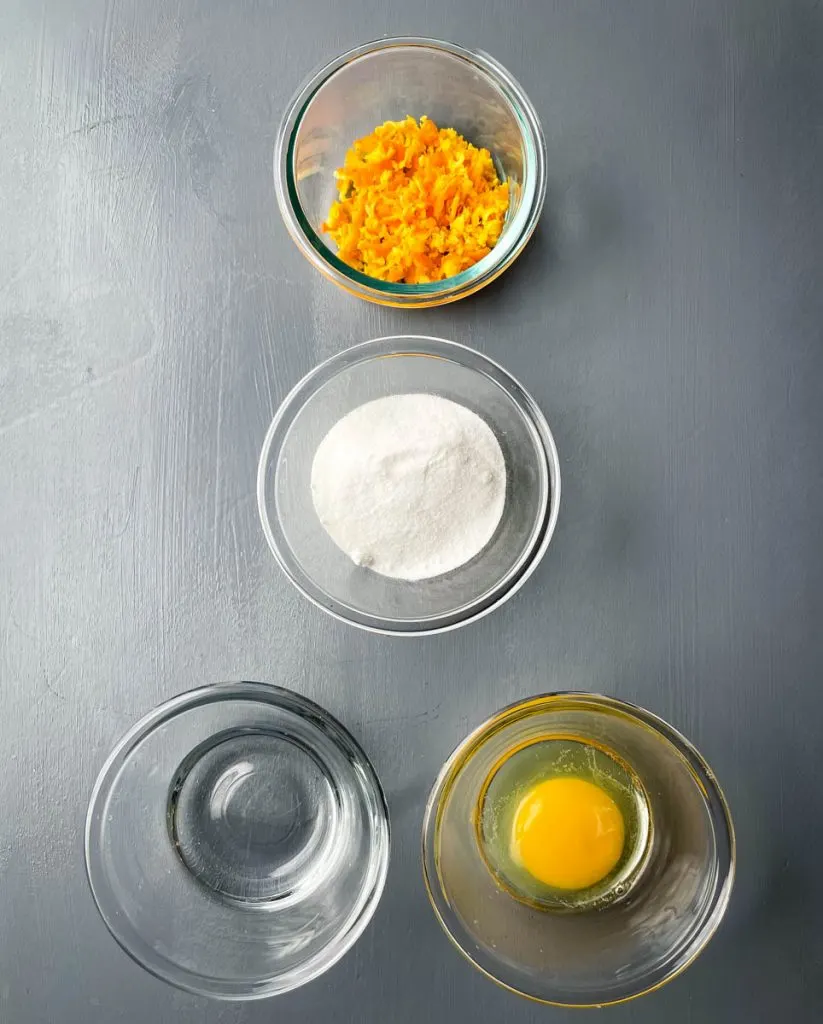 orange zest, sweetener, water, and an egg in separate bowls