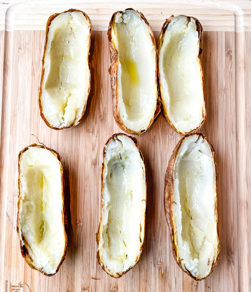 baked russet potatoes sliced in half on a cutting board