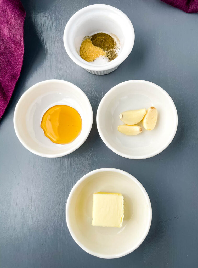 spices, butter, honey, and garlic in separate white bowls