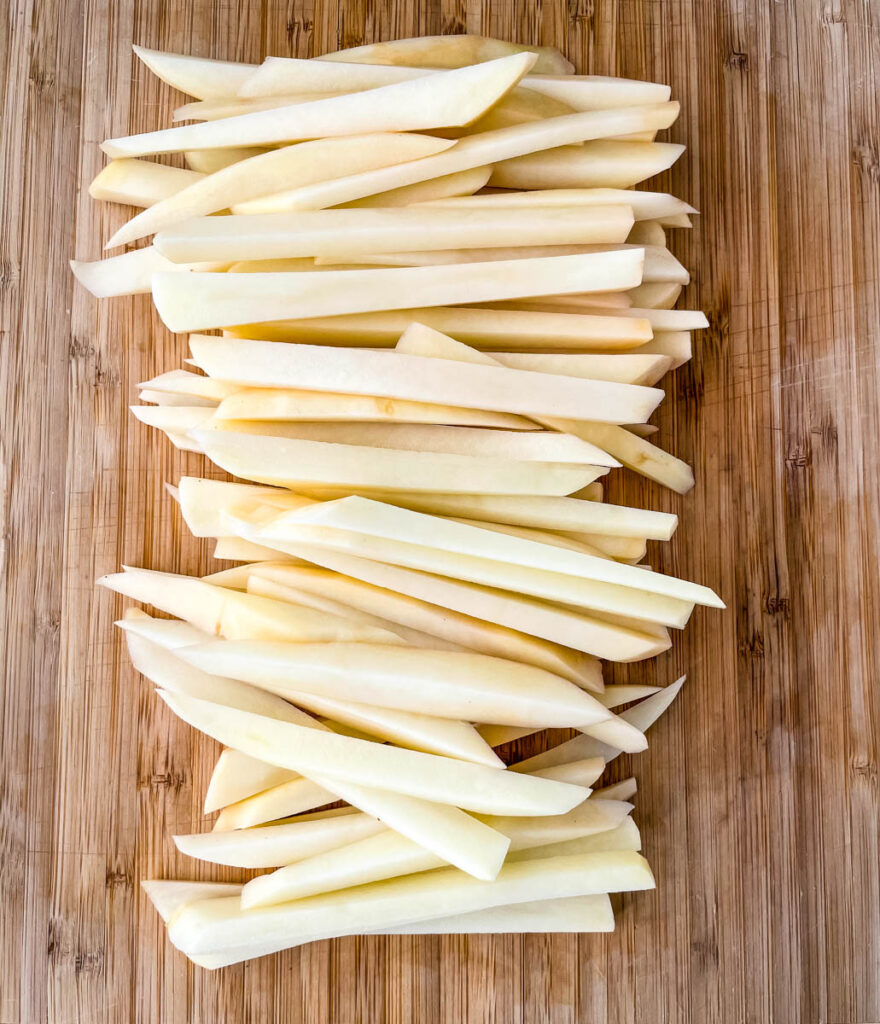 raw sliced potatoes on a cutting board