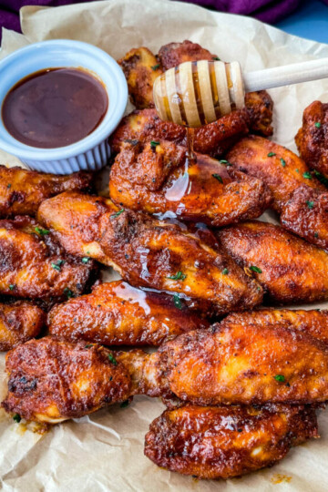 plate of keto low carb chicken wings being glazed with maple syrup