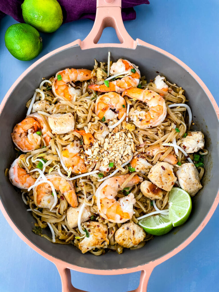 healthy pad thai with chicken, shrimp, bean sprouts, and lime in a pan