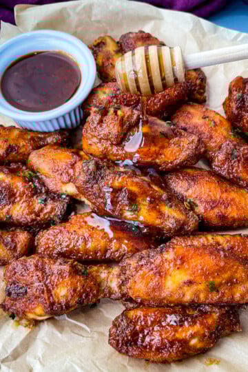 plate of keto low carb chicken wings being glazed with maple syrup