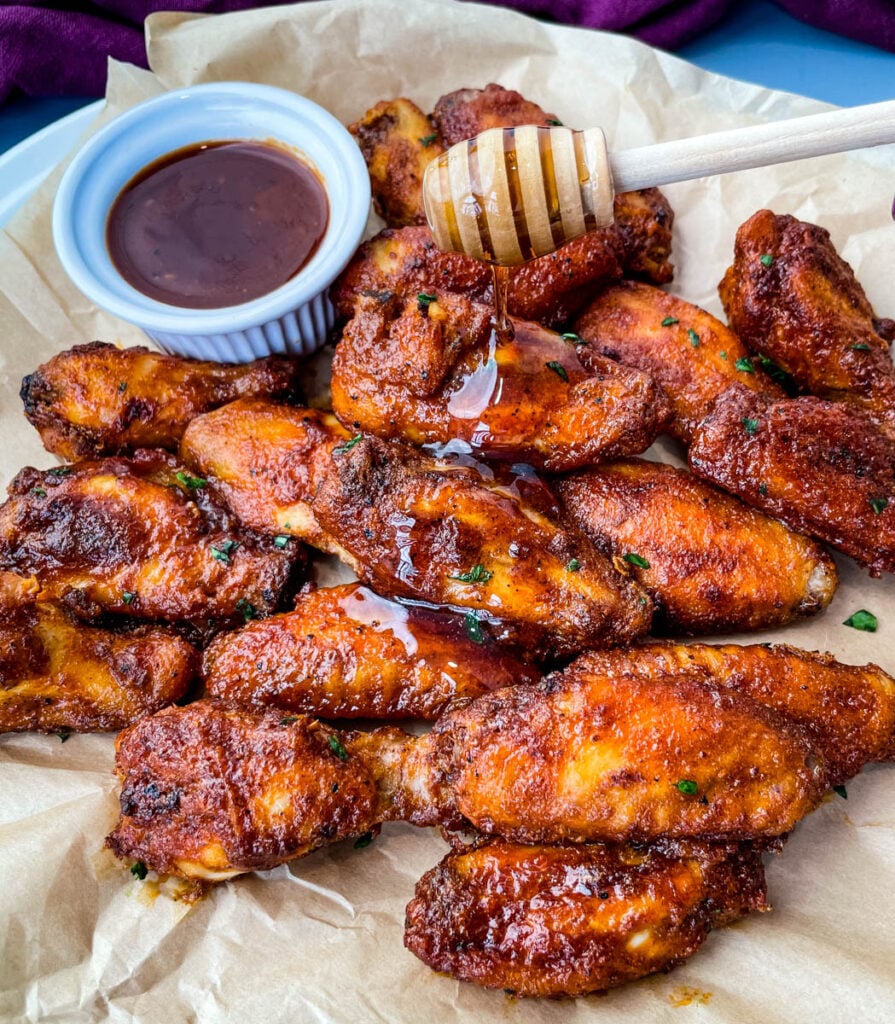 plate of keto low carb chicken wings being glazed with maple syrup