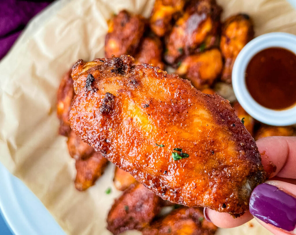 person holding keto chicken wing