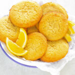 keto low carb lemon cookies on.a white plate with lemon wedges