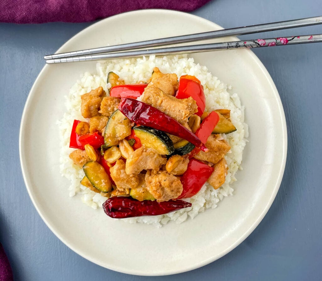 Panda Express copycat kung pao chicken on a white plate with chopsticks