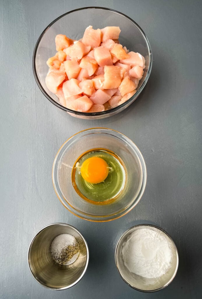 raw sliced chicken, raw egg, soy sauce, salt and pepper in separate bowls