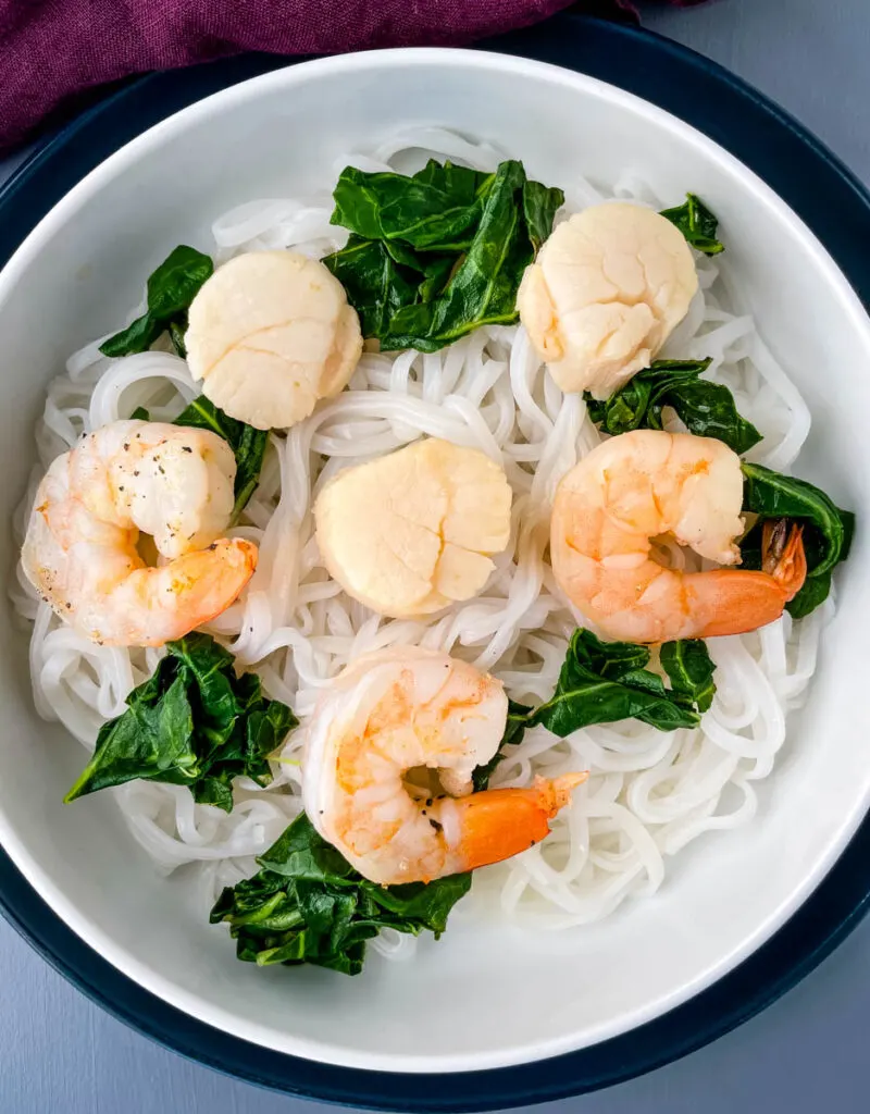 pho rice noodles in a white bowl with cooked shrimp and scallops