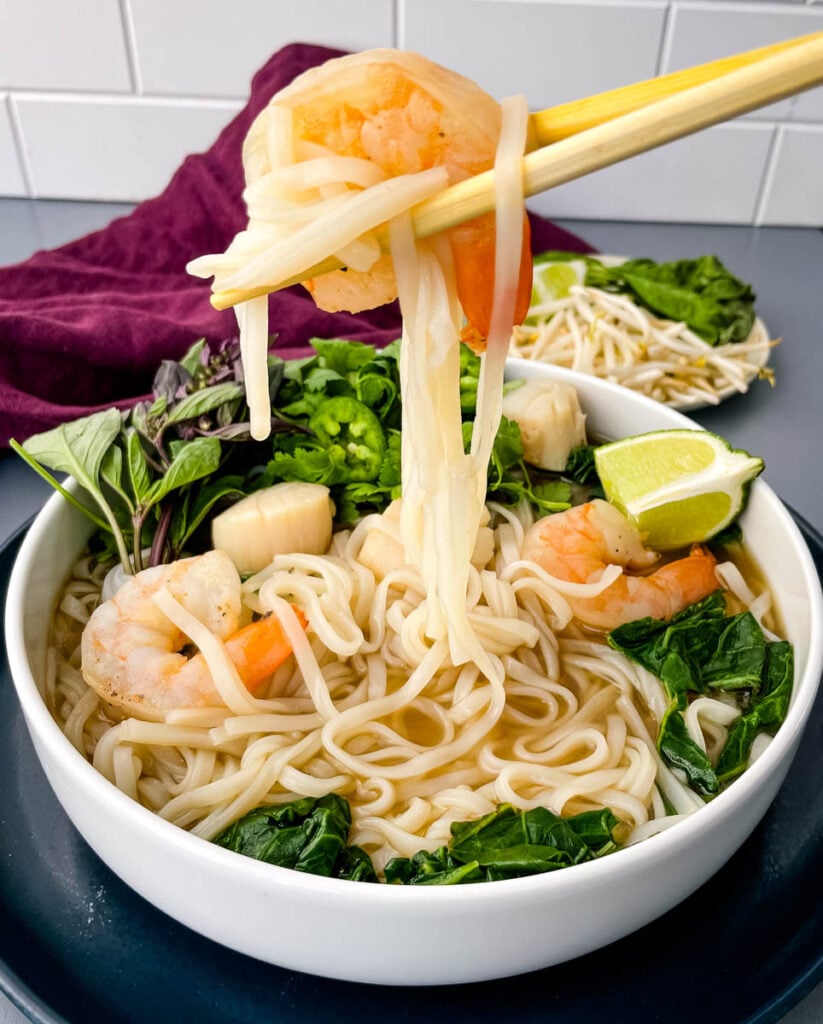 shrimp and pho held with chopsticks