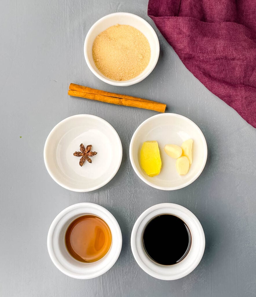 brown sugar, cinnamon stick, star anise, garlic, ginger, fish sauce, and soy sauce in separate bowls