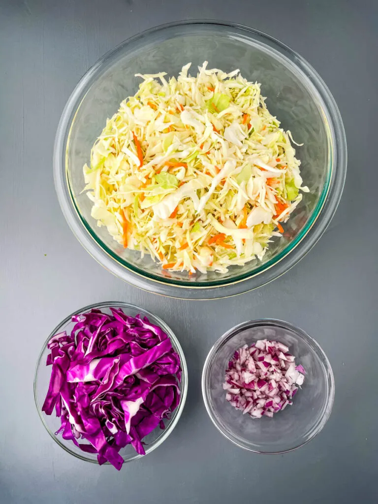 fresh coleslaw mix, red cabbage, onions in glass bowls