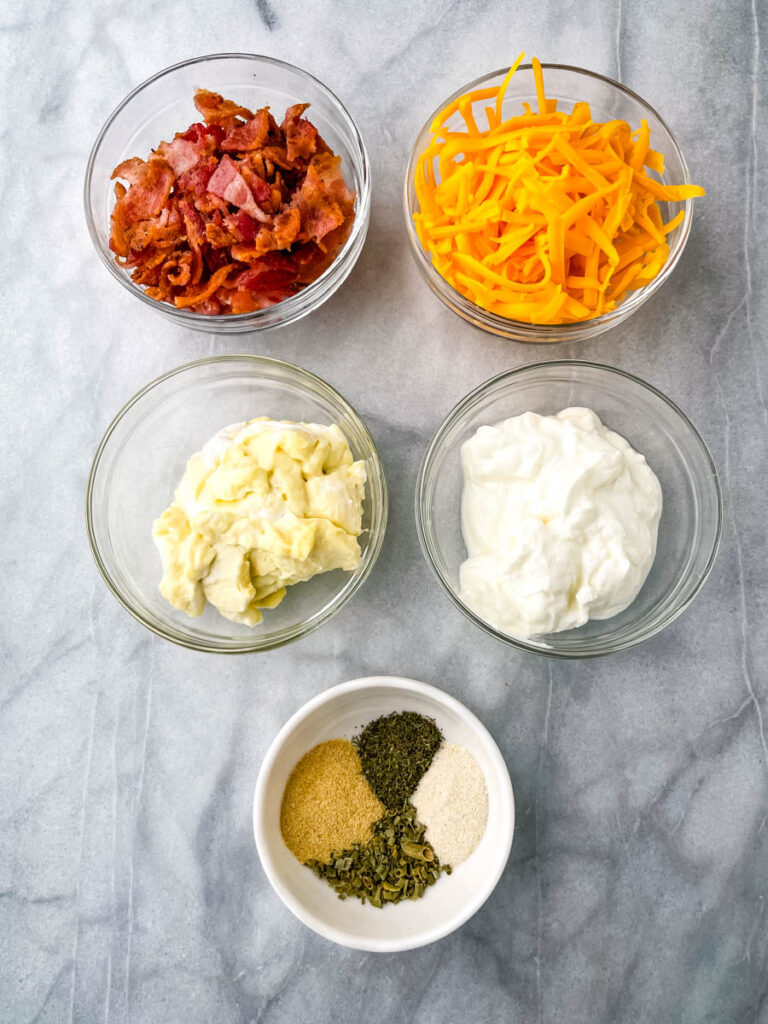 chopped bacon, shredded cheese, Greek yogurt, mayo, and homemade ranch seasoning in separate glass bowls