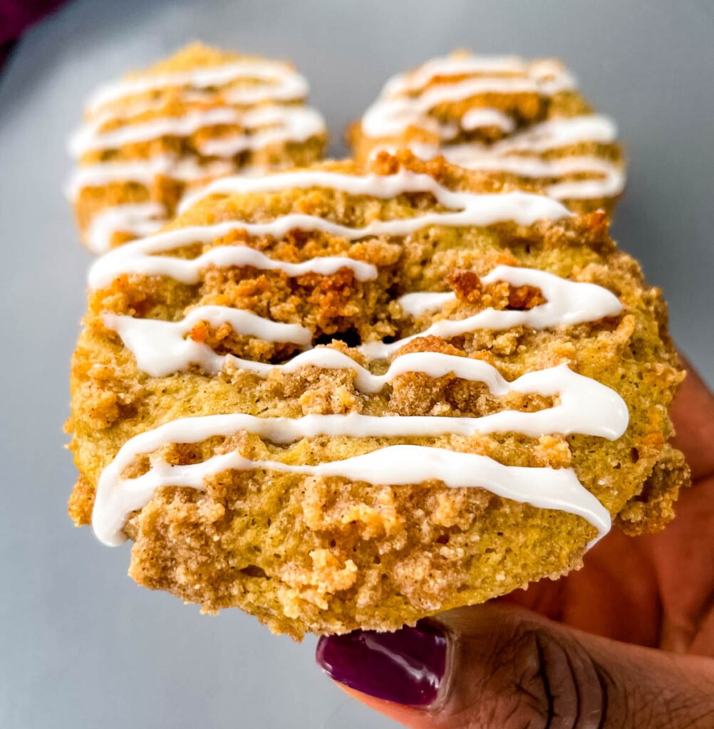 person holding coffee cake muffins with icing