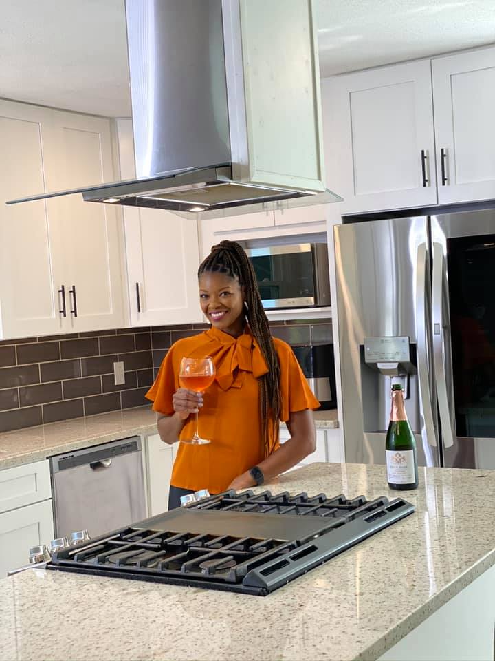 person holding wine in a kitchen