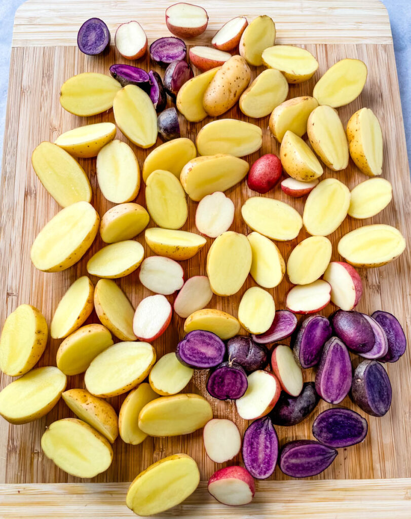 raw sliced potatoes on a bamboo cutting board