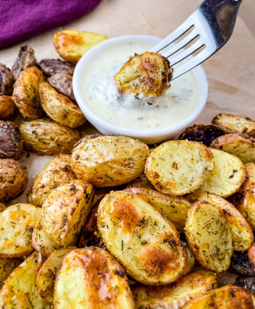 roasted ranch potatoes on a fork dipped in ranch dressing