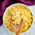 southern macaroni salad in a wooden spoon over a bowl