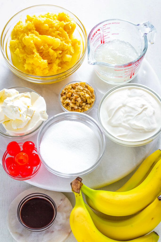 crushed pineapple, cherries, bananas, Greek yogurt, cream cheese, and sweetener in separate bowls