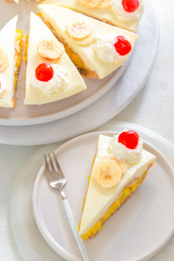 banana split pie on a plate with cherries and whipped cream