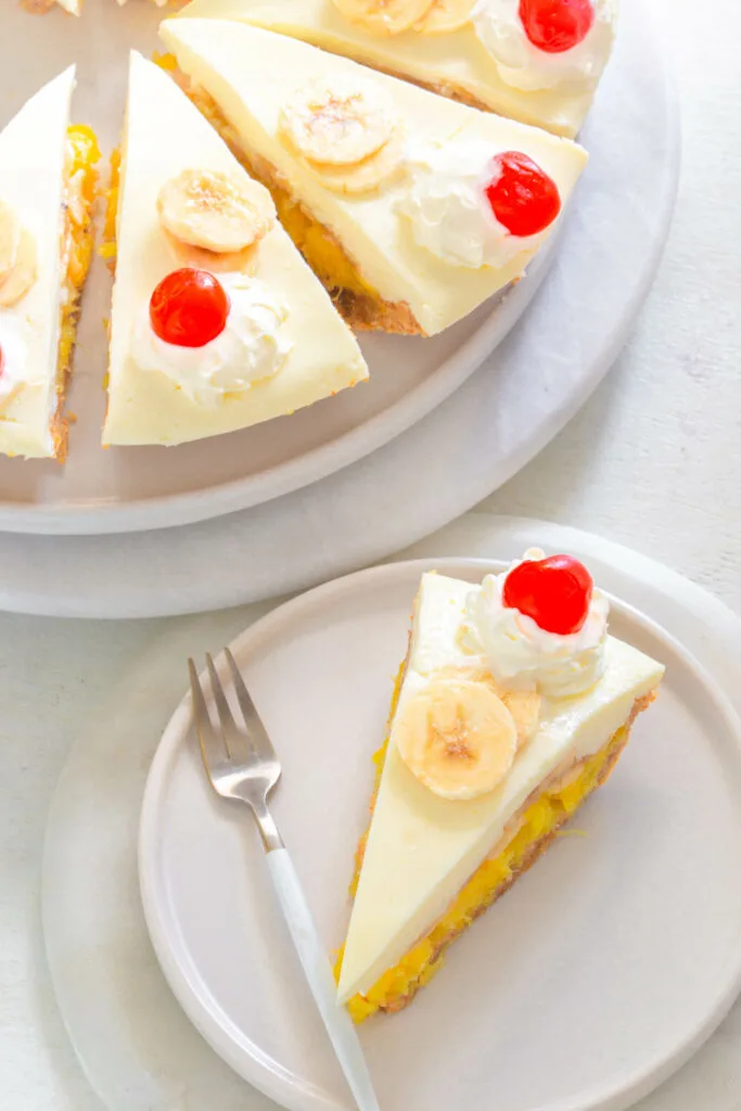 banana split pie on a plate with cherries and whipped cream