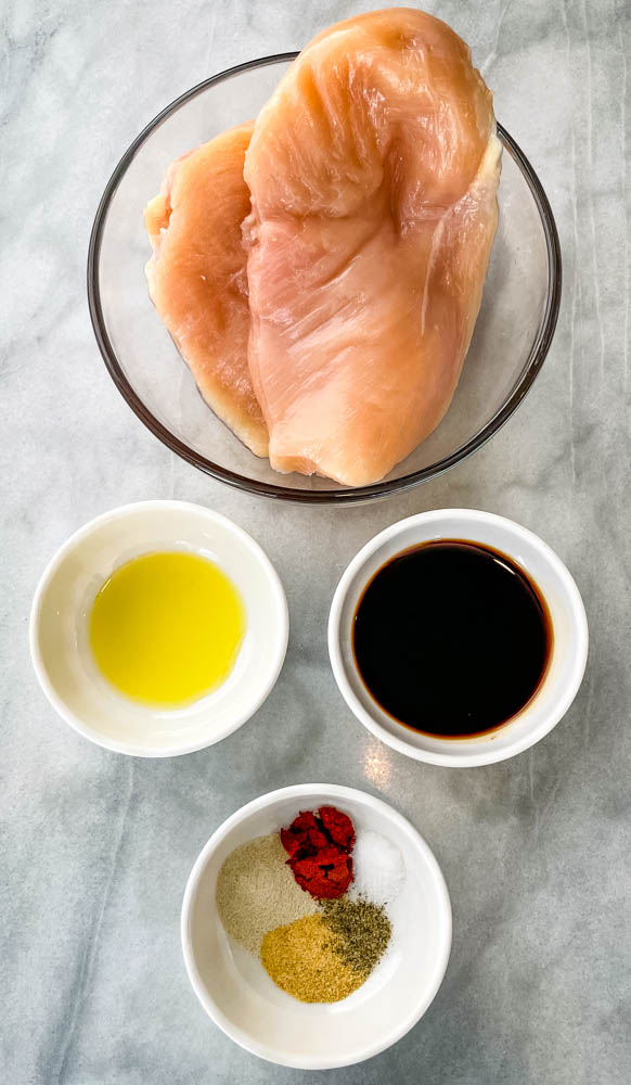 raw chicken breasts, olive oil, balsamic vinegar, and seasonings in separate bowls