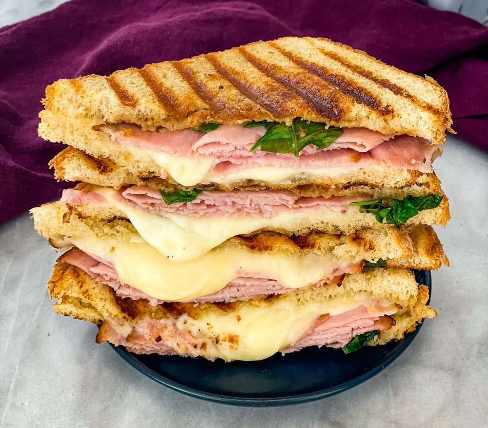 sliced ham and cheese panini sandwich on a plate