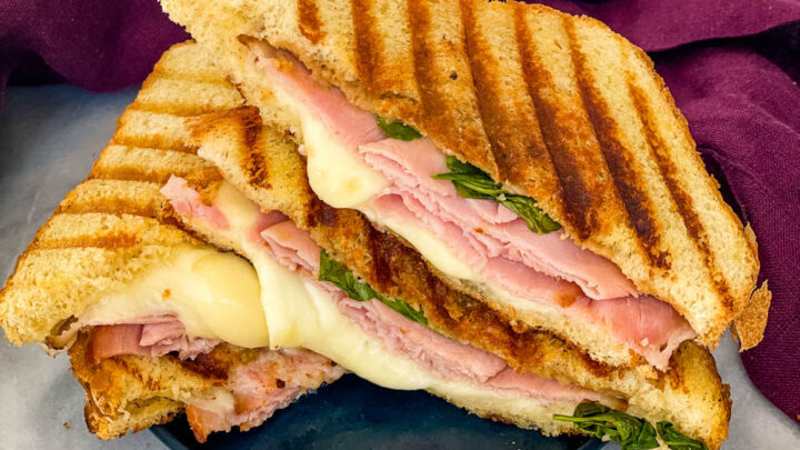 sliced ham and cheese panini sandwich on a plate