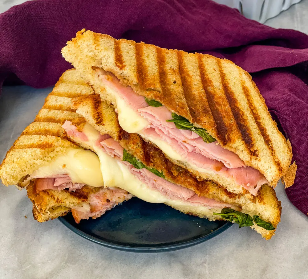 sliced ham and cheese panini sandwich on a plate