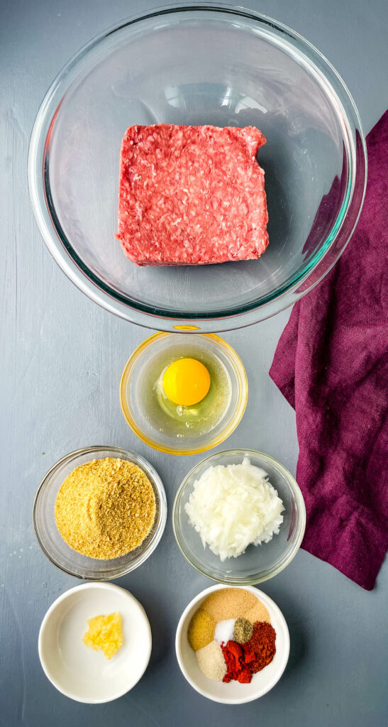 raw ground beef, raw egg, breadcrumbs, chopped onions, garlic, and BBQ rub in separate bowls