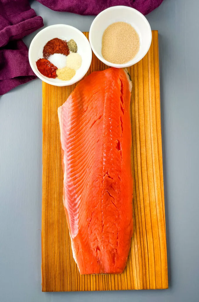raw salmon on a cedar plank with spices