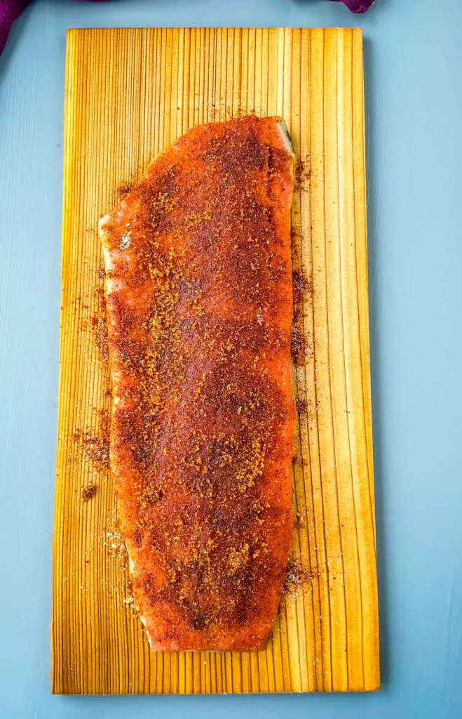 raw salmon on a cedar plank with spices