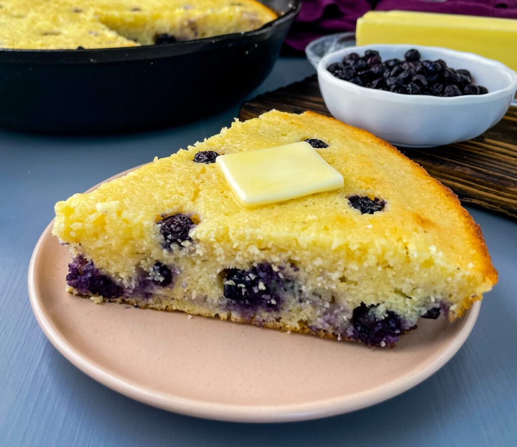 a slice of homemade blueberry cornbread on a plate