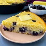 a slice of homemade blueberry cornbread on a plate