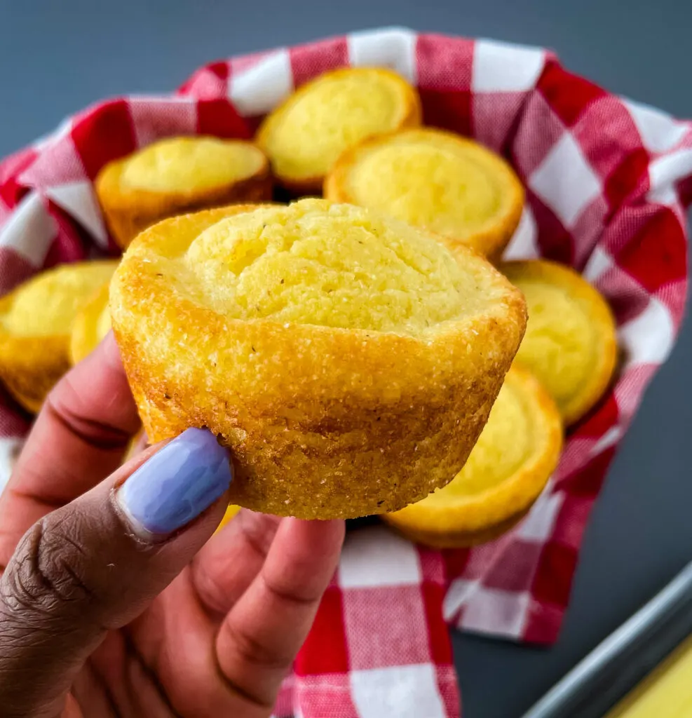 person holding cornbread muffin