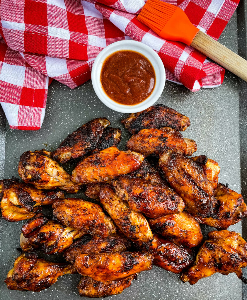 grilled chicken wings on a plate with BBQ sauce